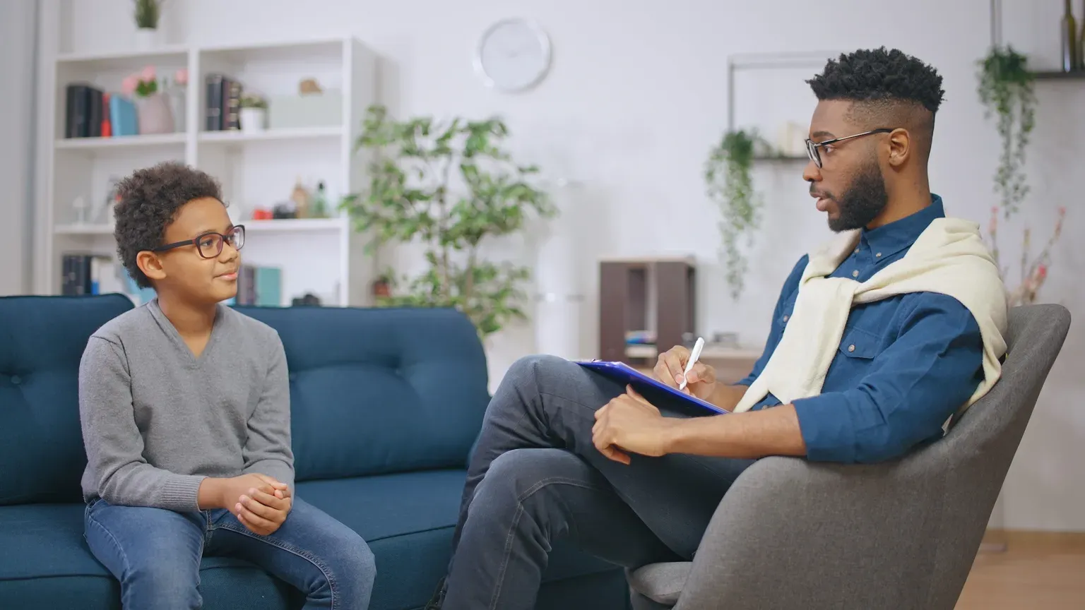 Schoolboy talking to a high-qualified psychologist in his office, mental health assessment